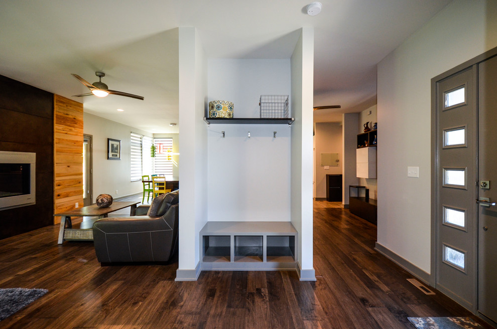This is an example of a large contemporary foyer in Kansas City with grey walls, medium hardwood flooring, a single front door, a grey front door and brown floors.