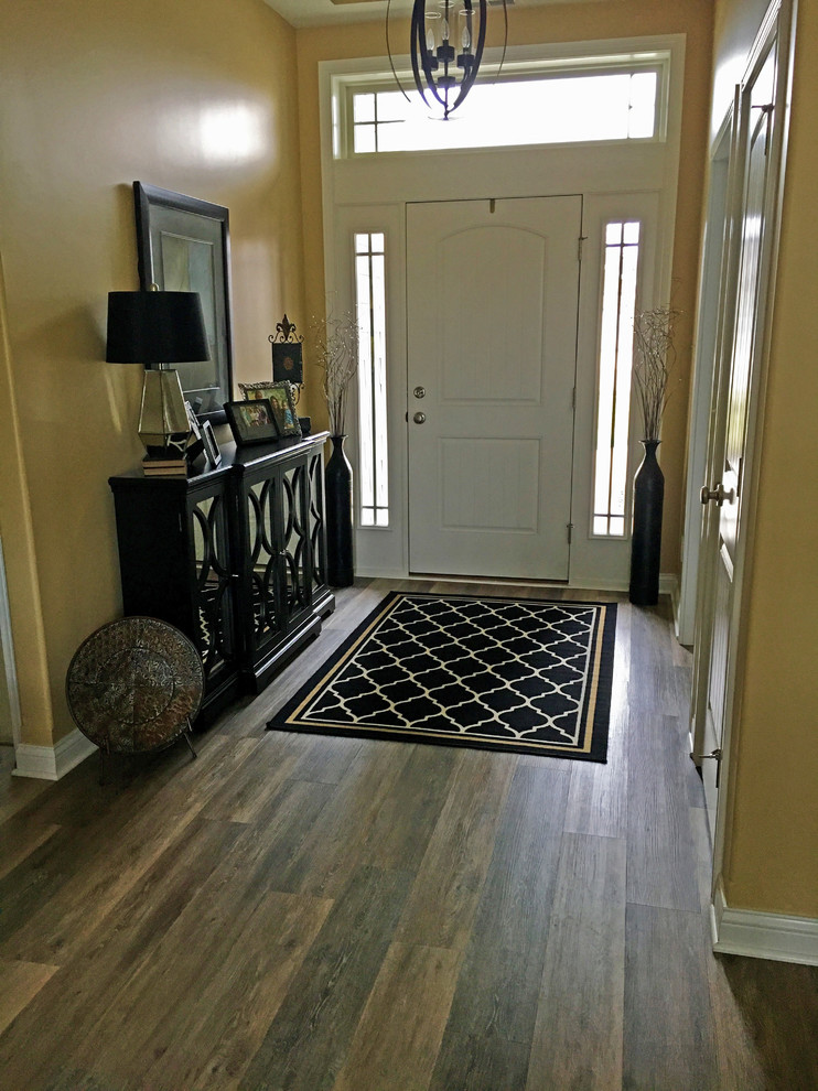 Cette image montre une entrée design avec un sol en vinyl, une porte simple, une porte blanche et un sol multicolore.