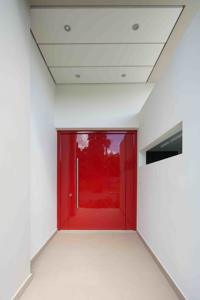 Ejemplo de puerta principal contemporánea grande con paredes blancas, suelo de baldosas de cerámica, puerta pivotante y puerta roja