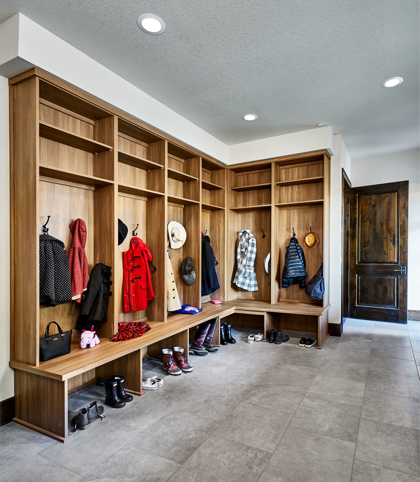 Photo of a large country boot room in Portland with ceramic flooring, grey floors, white walls, a single front door, a dark wood front door and feature lighting.