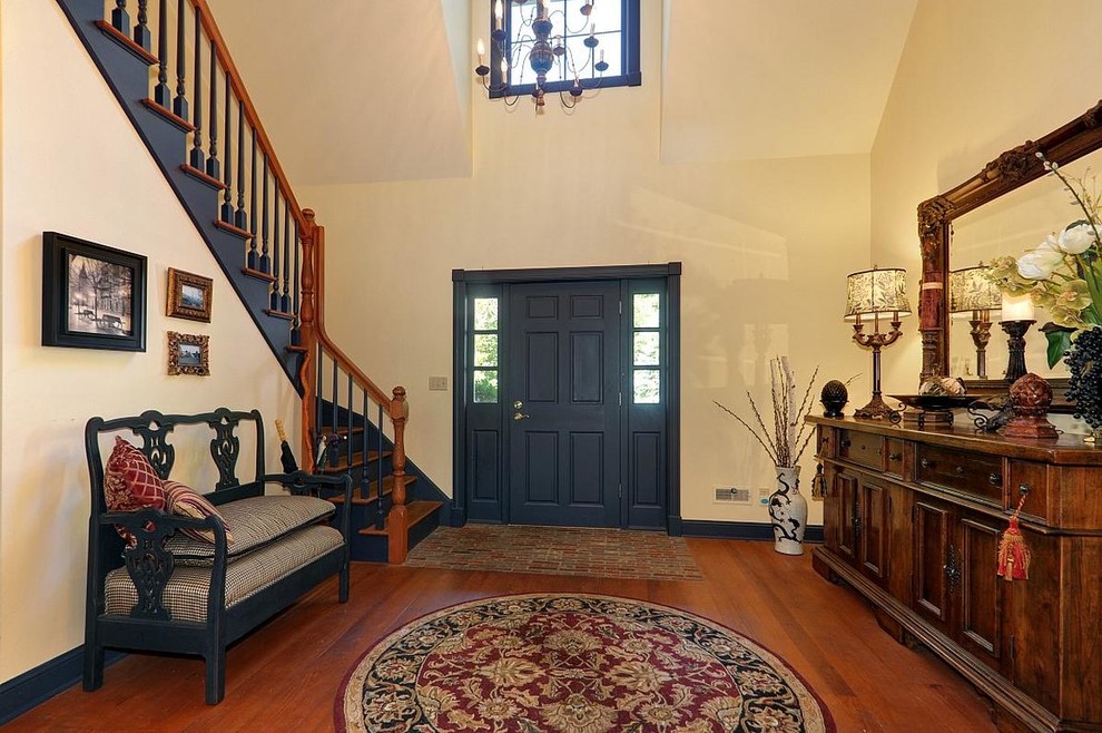 Example of a mid-sized mountain style medium tone wood floor entryway design in Milwaukee with yellow walls and a blue front door