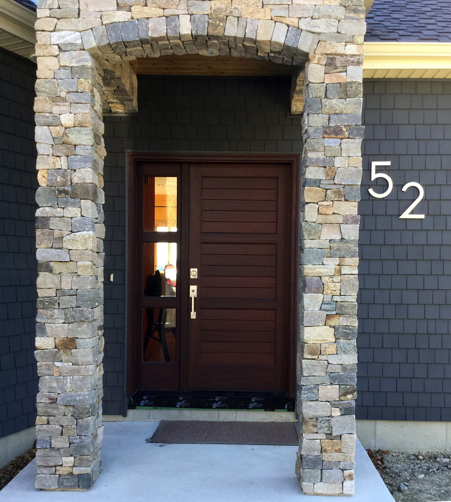 Cette image montre une porte d'entrée design avec un mur gris, une porte simple, une porte en bois foncé et un sol en bois brun.