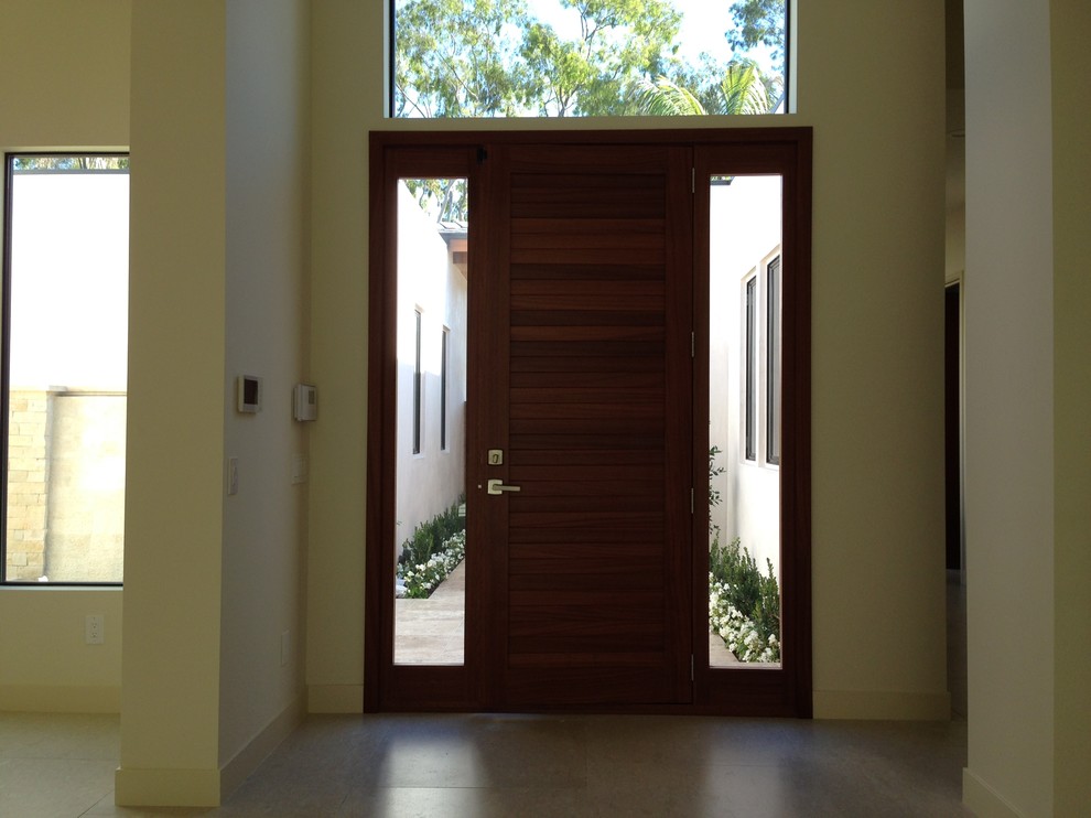 На фото: маленькая входная дверь в морском стиле с бежевыми стенами, полом из керамической плитки, одностворчатой входной дверью, входной дверью из дерева среднего тона и бежевым полом для на участке и в саду