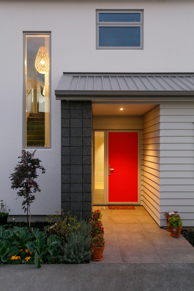 Exemple d'une porte d'entrée tendance avec un mur blanc, une porte simple et une porte rouge.