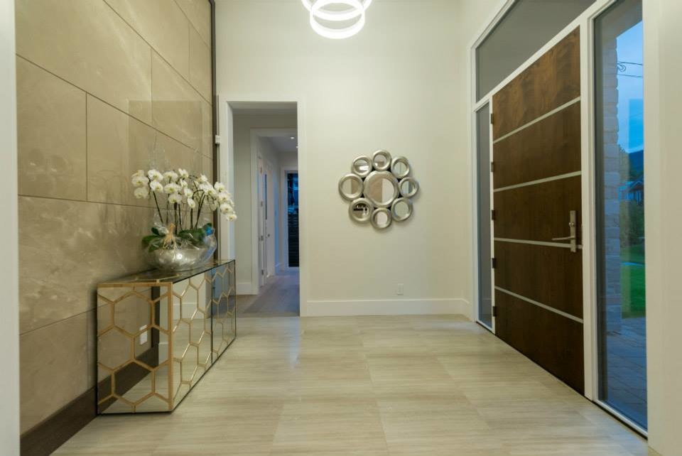 Entryway - large contemporary marble floor entryway idea in Vancouver with beige walls and a dark wood front door