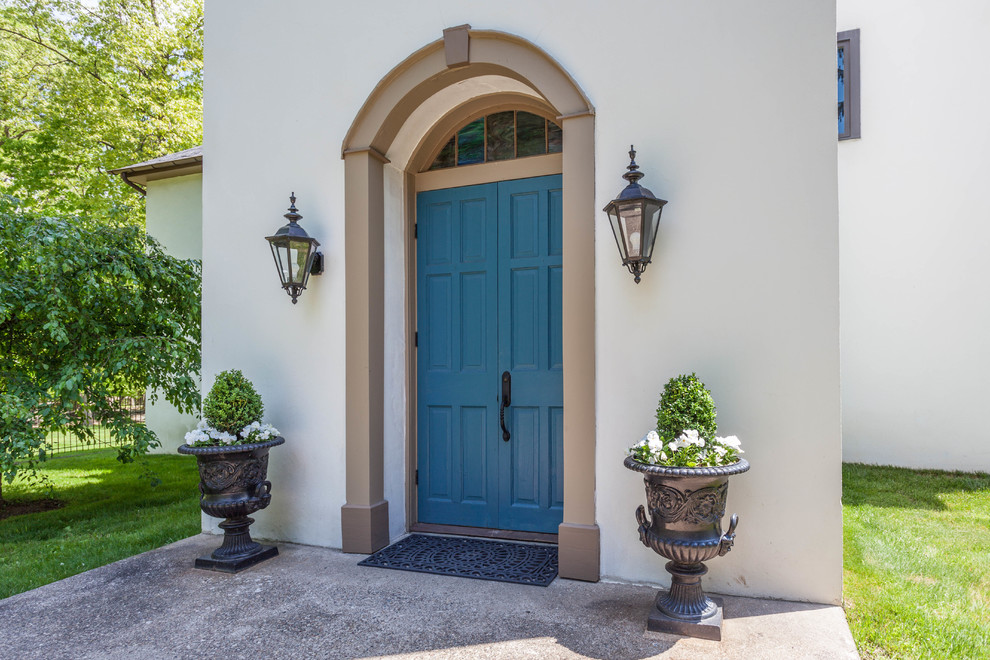 На фото: входная дверь среднего размера в классическом стиле с белыми стенами, бетонным полом, двустворчатой входной дверью, синей входной дверью и серым полом с