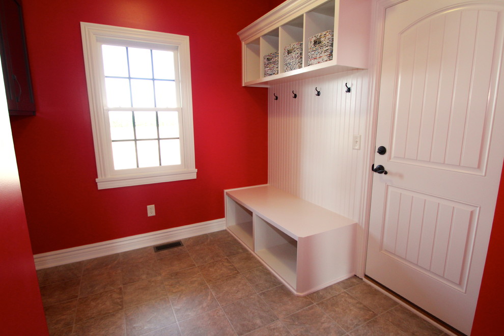 Aménagement d'une grande entrée craftsman avec un mur rouge, un sol en vinyl, un vestiaire, une porte simple et une porte blanche.