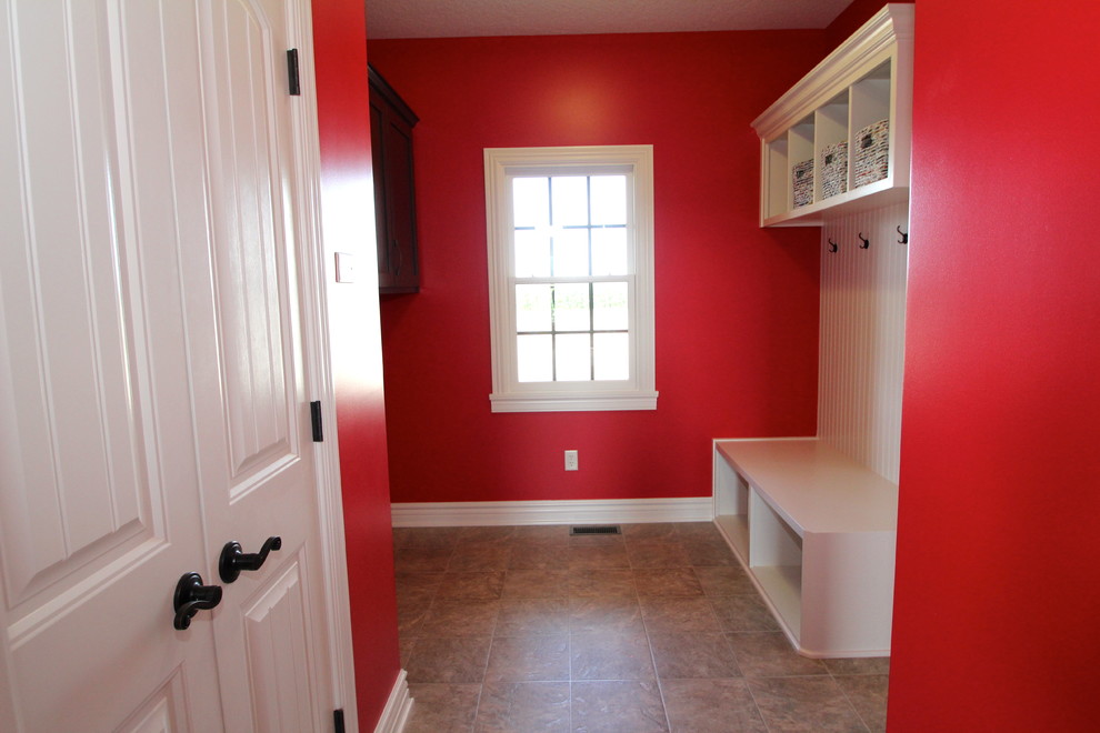 На фото: большой тамбур в стиле кантри с красными стенами, полом из винила, одностворчатой входной дверью и белой входной дверью