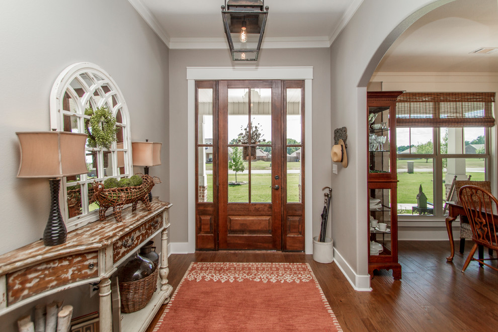 Mid-sized elegant medium tone wood floor and brown floor entryway photo in Little Rock with gray walls and a dark wood front door
