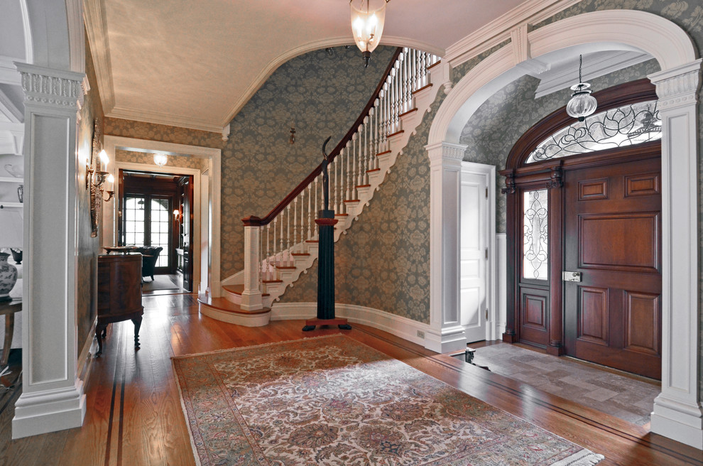 Photo of a large traditional foyer in New York with multi-coloured walls, medium hardwood flooring, a single front door and a brown front door.