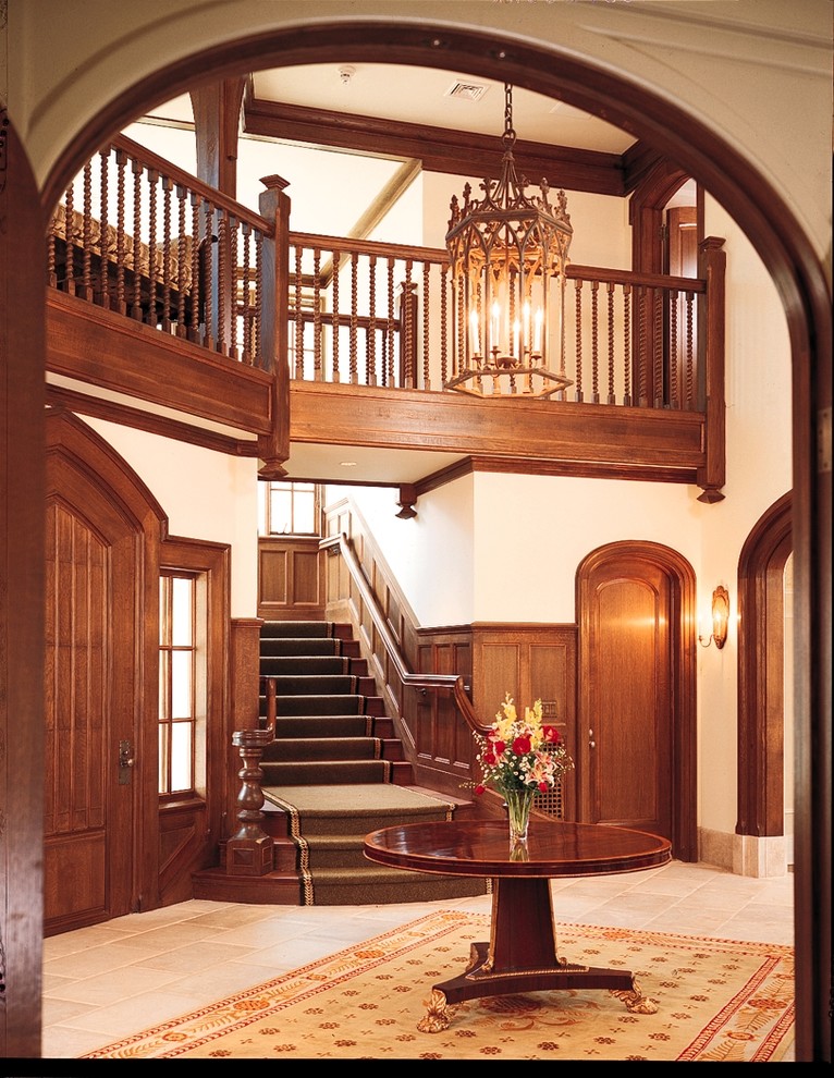 Diseño de hall clásico extra grande con paredes blancas, suelo de piedra caliza, puerta simple y puerta de madera en tonos medios