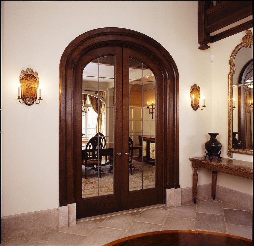 Imagen de hall clásico extra grande con paredes blancas, suelo de piedra caliza, puerta simple y puerta de madera en tonos medios