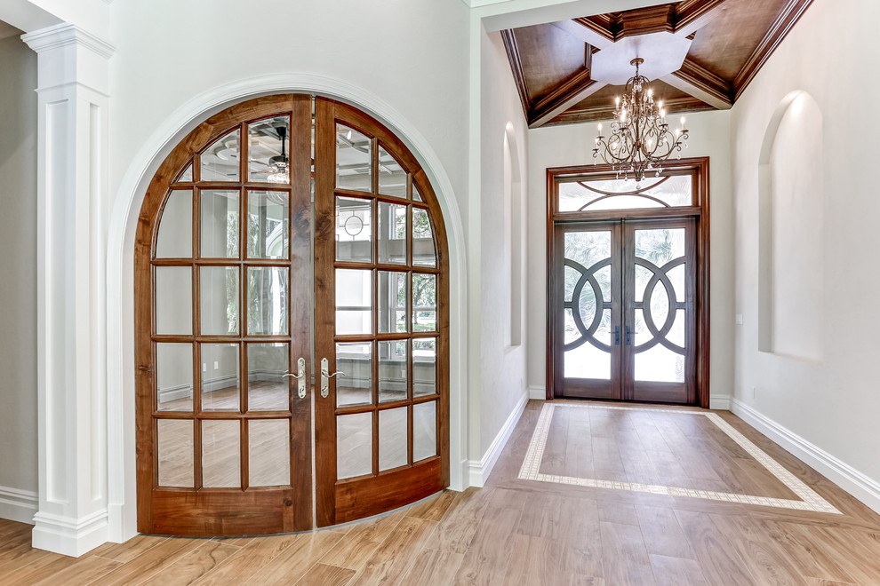 Idées déco pour une grande porte d'entrée classique avec un mur gris, parquet clair, une porte double, une porte en verre et un sol marron.