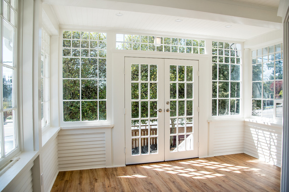 Imagen de puerta principal tradicional con paredes blancas, puerta simple, puerta de madera oscura, suelo marrón y suelo vinílico