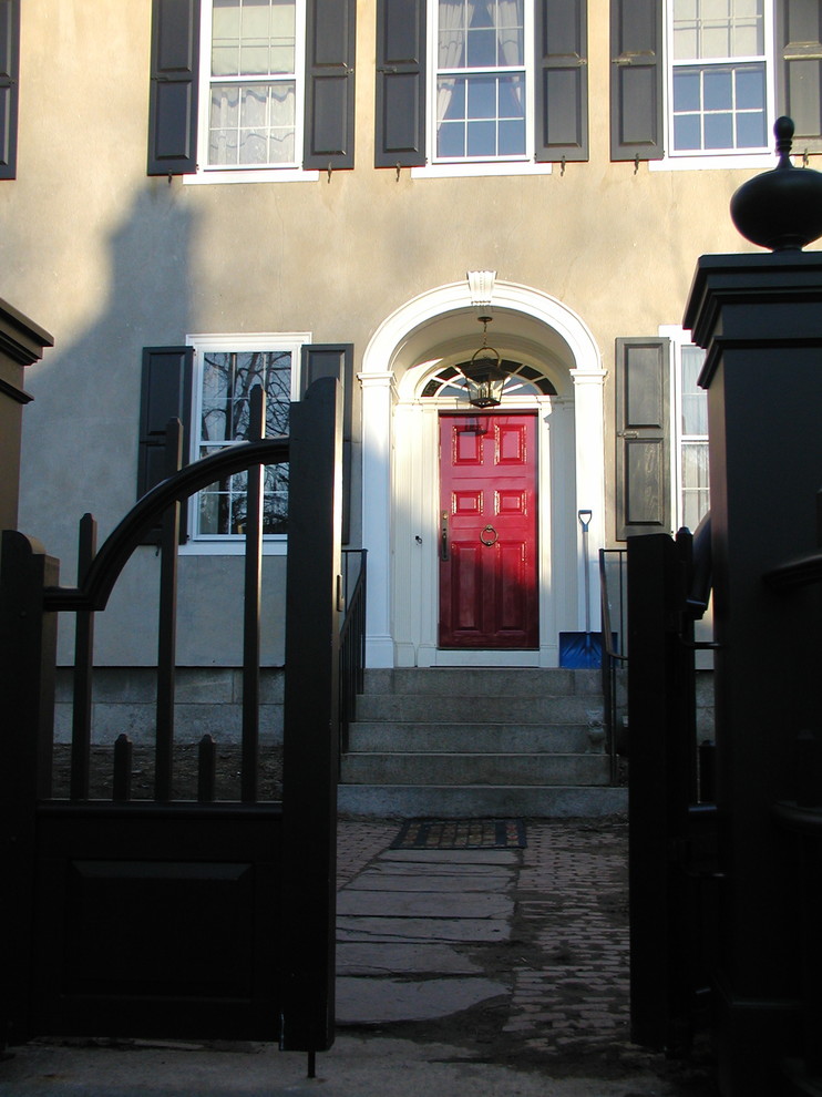 Foto di una grande porta d'ingresso chic con pareti grigie, pavimento in granito, una porta singola e una porta rossa