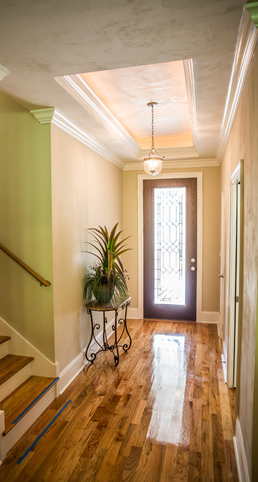 Inspiration for a large craftsman medium tone wood floor entryway remodel in Atlanta with beige walls and a dark wood front door