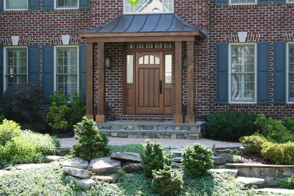 Idée de décoration pour une porte d'entrée tradition de taille moyenne avec un sol en ardoise, une porte simple et une porte en bois brun.