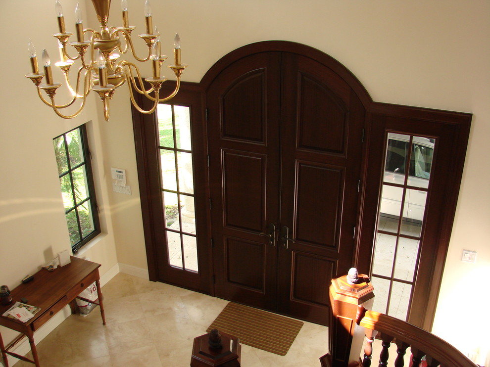 Idee per un ingresso tradizionale di medie dimensioni con pareti bianche, pavimento con piastrelle in ceramica, una porta a due ante e una porta in legno scuro