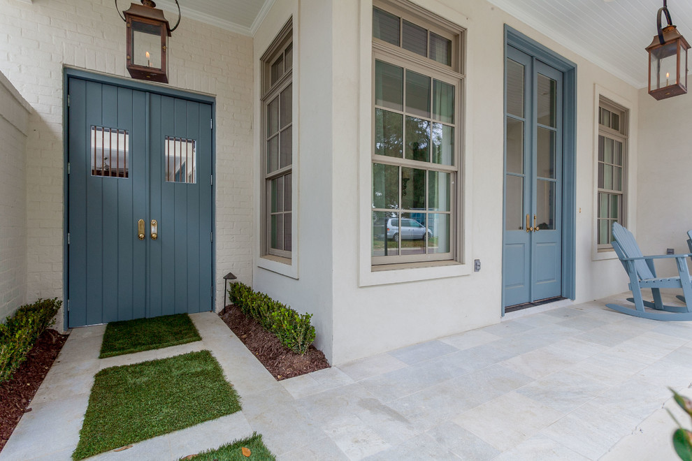 This is an example of a classic front door in New Orleans with beige walls, a double front door and a blue front door.