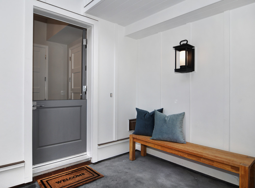На фото: маленькая узкая прихожая в морском стиле с белыми стенами, бетонным полом, голландской входной дверью, серой входной дверью и серым полом для на участке и в саду с
