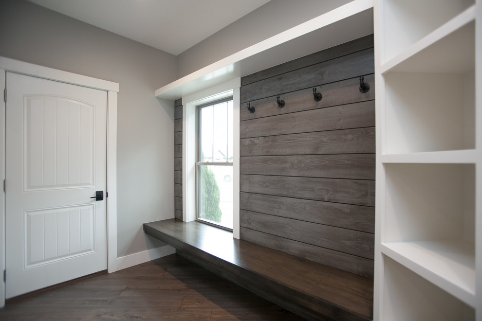 Idéer för att renovera en mellanstor vintage foajé, med grå väggar, mellanmörkt trägolv, en svart dörr och brunt golv