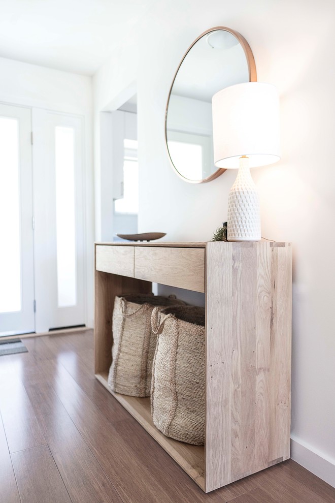 Photo of a medium sized scandi hallway in San Francisco with white walls, medium hardwood flooring, a glass front door, brown floors and feature lighting.