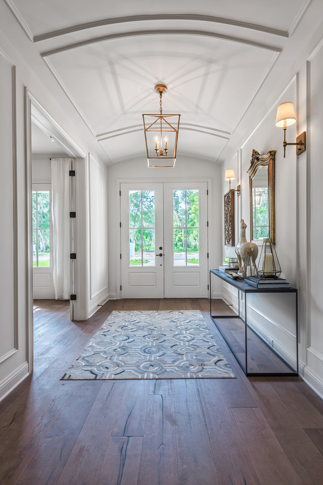 Klassisches Foyer mit weißer Wandfarbe, dunklem Holzboden, Doppeltür und weißer Haustür in Jacksonville