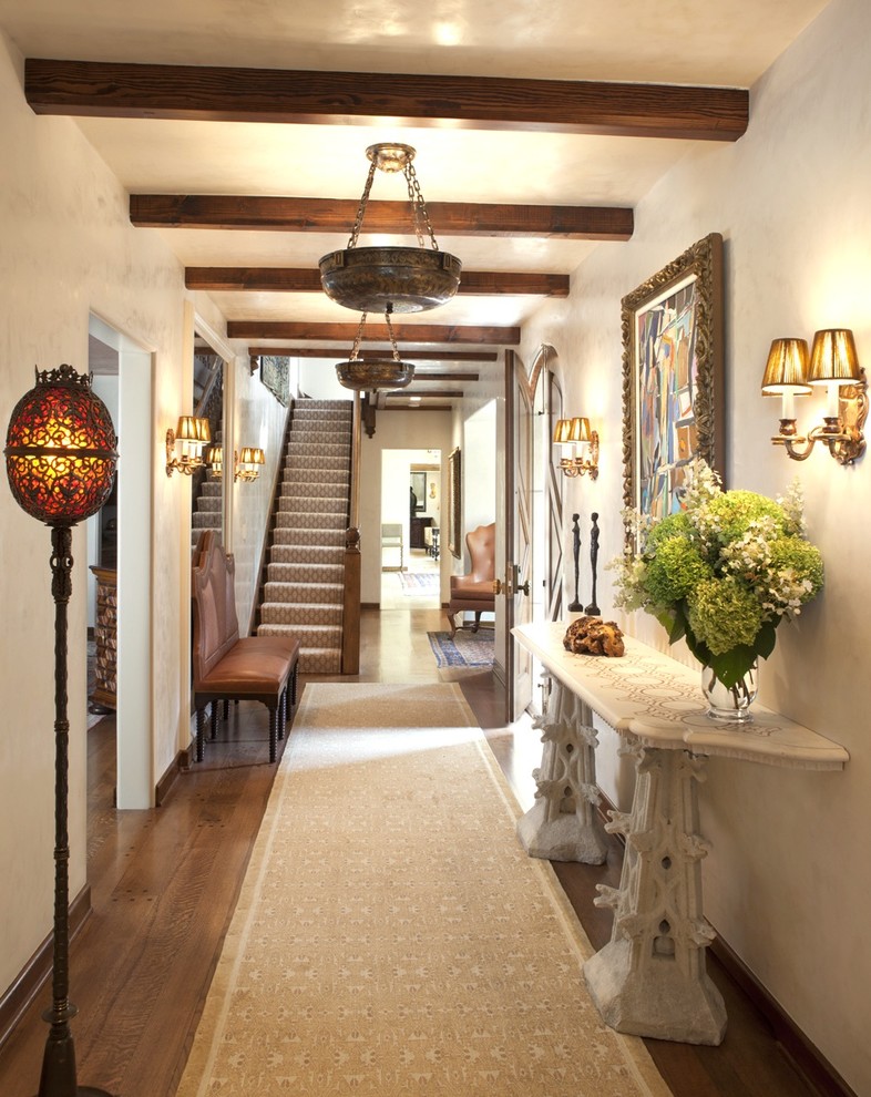 Inspiration pour une entrée traditionnelle avec un couloir, un mur beige et un sol en bois brun.