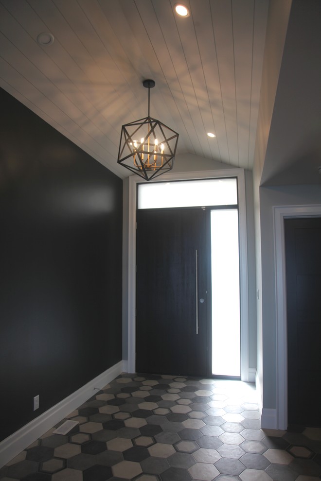 На фото: фойе среднего размера в стиле фьюжн с черными стенами, полом из керамогранита, раздвижной входной дверью, входной дверью из темного дерева и разноцветным полом с