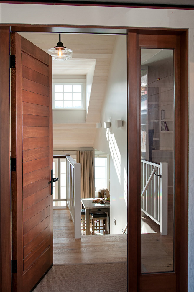 Imagen de puerta principal clásica renovada de tamaño medio con paredes blancas, suelo de madera en tonos medios, puerta simple y puerta de madera en tonos medios