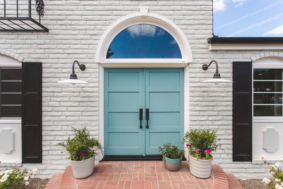 Imagen de puerta principal tradicional renovada con paredes blancas, puerta doble y puerta azul