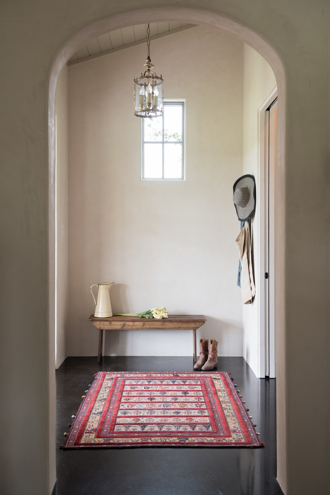 На фото: тамбур в стиле кантри с белыми стенами, бетонным полом и коричневым полом