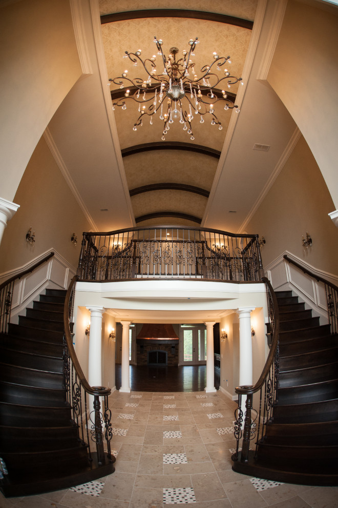 This is an example of an expansive foyer in Cincinnati with beige walls, marble flooring, a dark wood front door and multi-coloured floors.