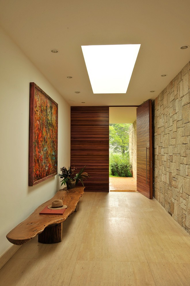 Foto de hall actual grande con paredes beige, puerta pivotante y puerta de madera en tonos medios