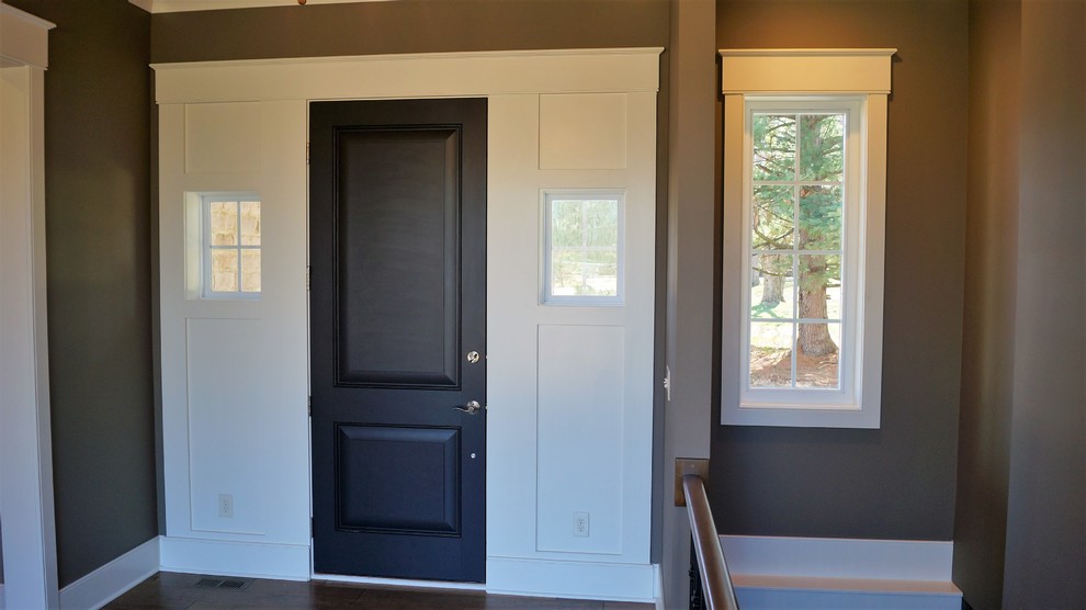 Foto di un'ampia porta d'ingresso tradizionale con pareti marroni, una porta singola e una porta nera