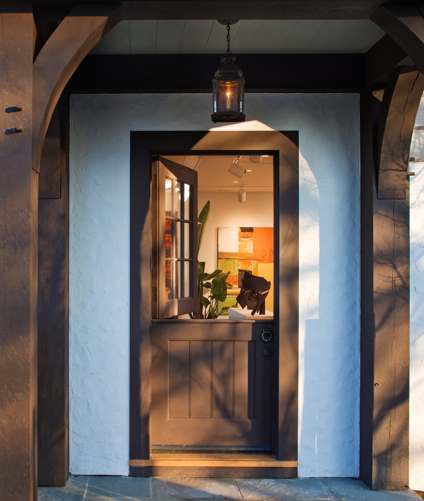 Lantlig inredning av en ingång och ytterdörr, med en tvådelad stalldörr och en brun dörr