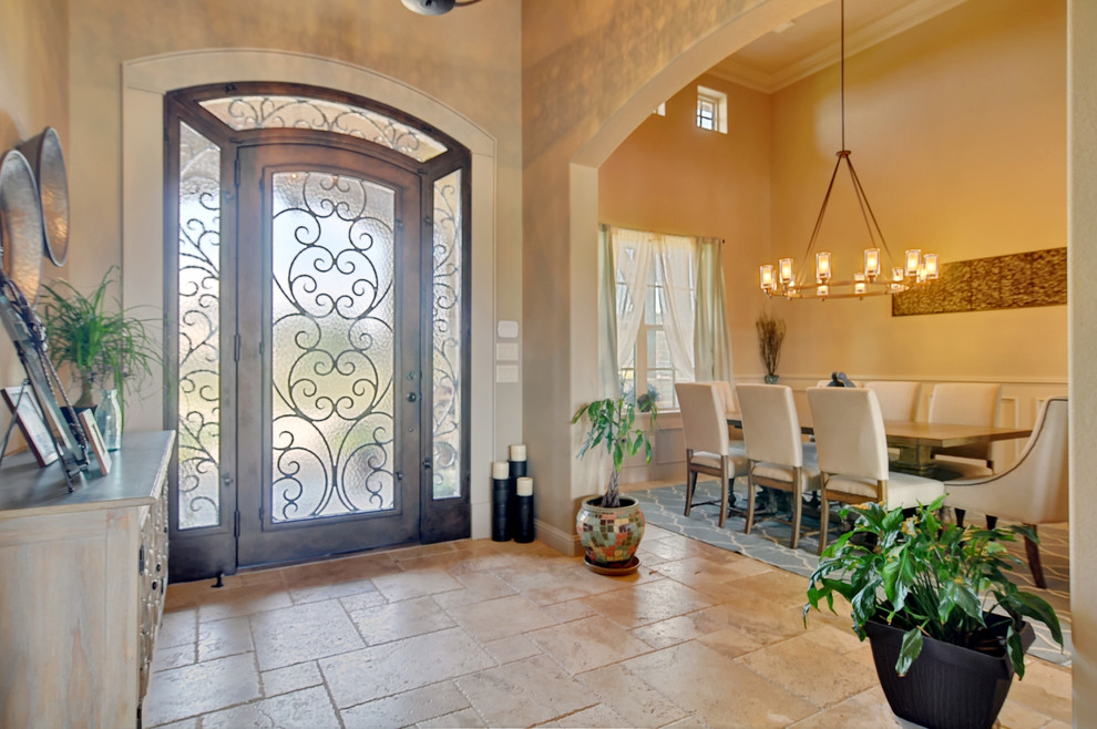 ダラスにある広いトランジショナルスタイルのおしゃれな玄関ロビー (ベージュの壁、トラバーチンの床、茶色いドア) の写真