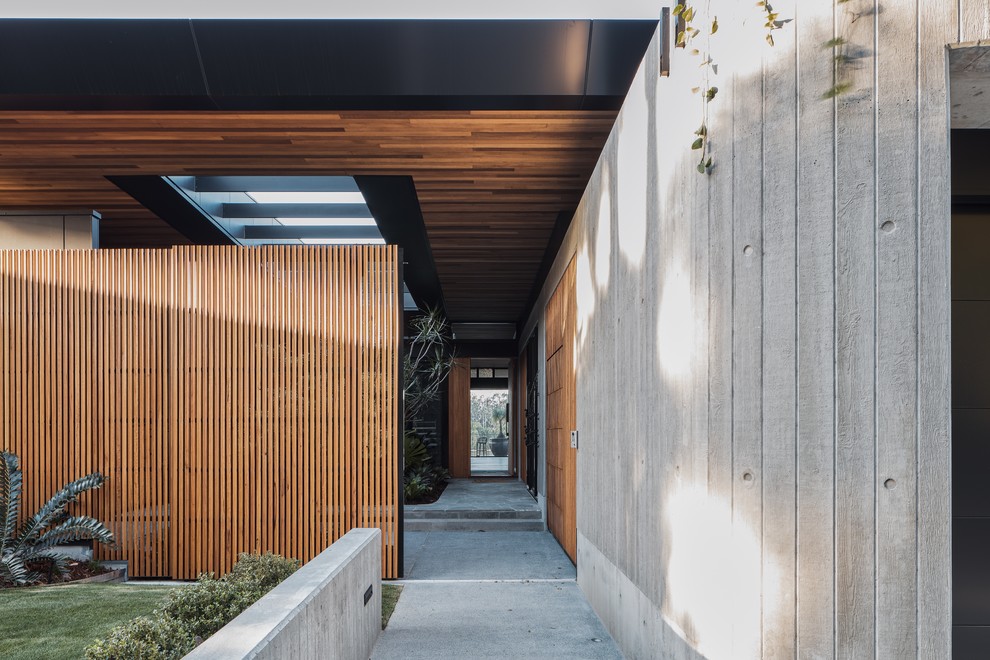Idées déco pour une porte d'entrée contemporaine avec un mur marron, sol en béton ciré et un sol gris.