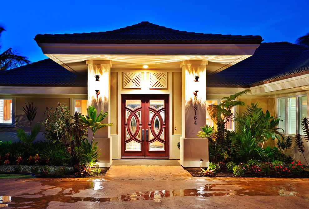 Imagen de puerta principal tropical de tamaño medio con paredes beige, suelo de cemento, puerta doble y puerta de madera en tonos medios