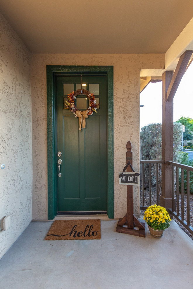 Immagine di una porta d'ingresso country di medie dimensioni con pareti beige, pavimento in cemento, una porta singola, una porta verde e pavimento grigio