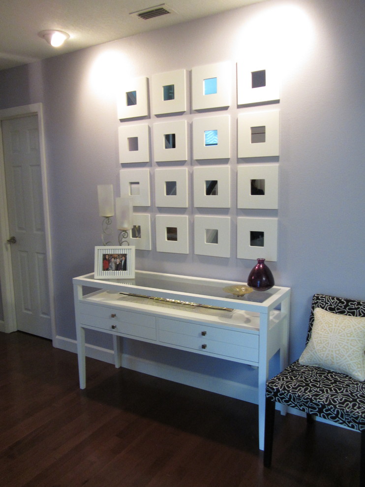 Inspiration pour un petit hall d'entrée minimaliste avec un mur violet et un sol en bois brun.
