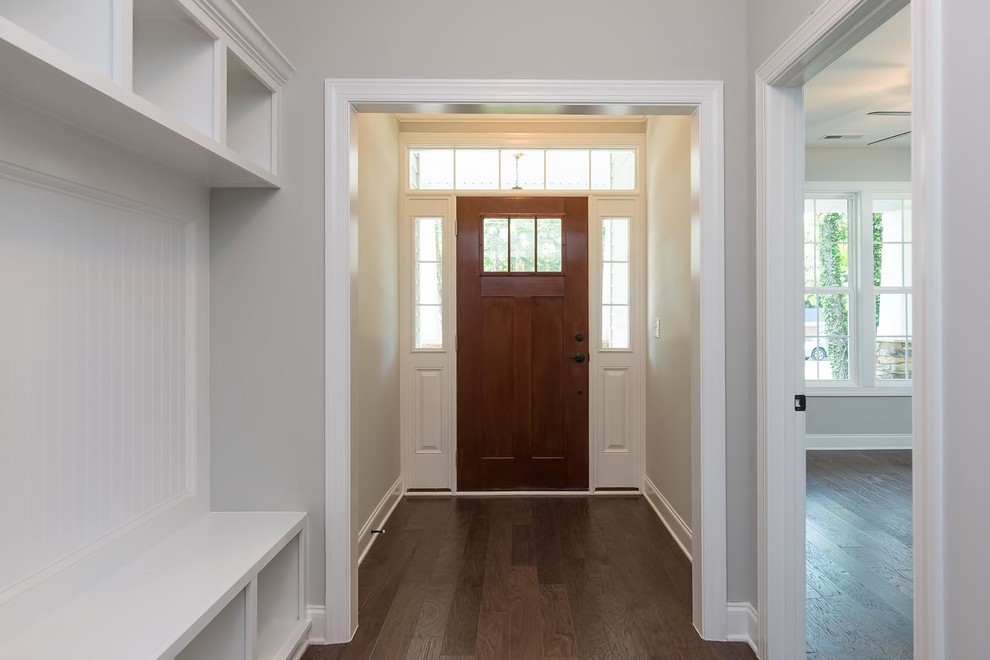 Inspiration pour un hall d'entrée traditionnel de taille moyenne avec un mur gris, un sol en bois brun, une porte simple et une porte marron.