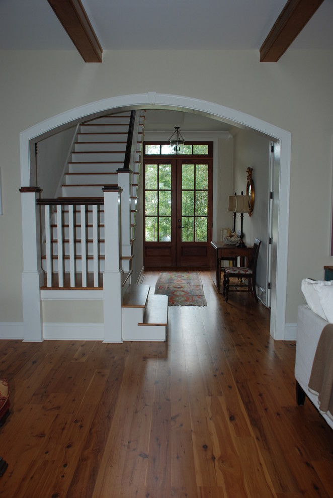 Klassisches Foyer mit Doppeltür, Haustür aus Glas, braunem Holzboden und beiger Wandfarbe in Charleston
