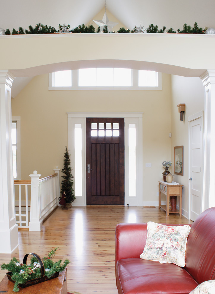 Small arts and crafts light wood floor front door photo in Cedar Rapids with beige walls and a dark wood front door