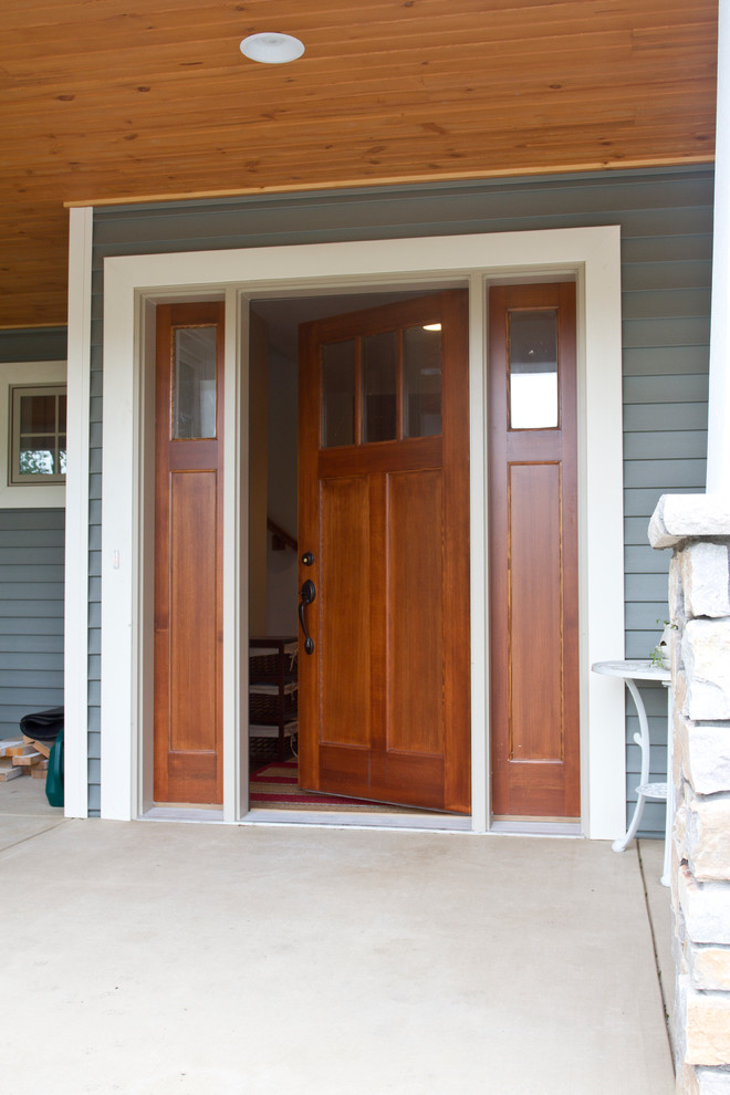 На фото: входная дверь среднего размера в стиле кантри с одностворчатой входной дверью и входной дверью из дерева среднего тона с