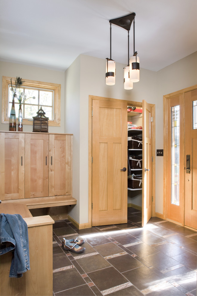 Idée de décoration pour une entrée craftsman avec un vestiaire, une porte simple et une porte en bois clair.
