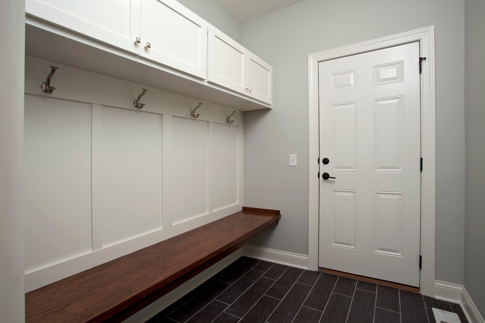 Aménagement d'une entrée classique avec un vestiaire, un mur gris, un sol en carrelage de céramique, une porte simple et une porte blanche.