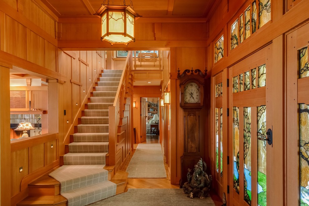 Example of a large arts and crafts light wood floor entryway design in Portland Maine with a light wood front door