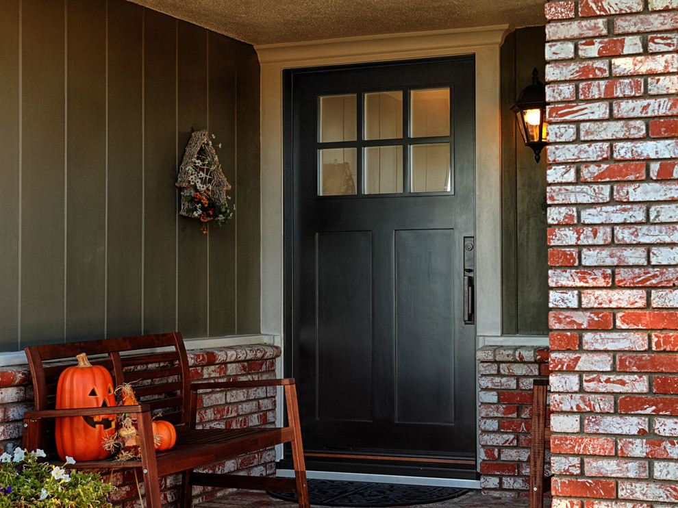 Cette photo montre une porte d'entrée craftsman de taille moyenne avec un mur orange, une porte simple et une porte noire.