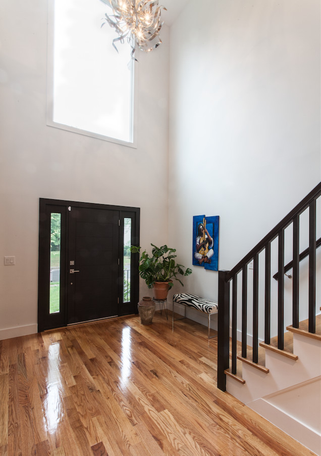 Großes Eklektisches Foyer mit weißer Wandfarbe, hellem Holzboden, Einzeltür und dunkler Holzhaustür in New York